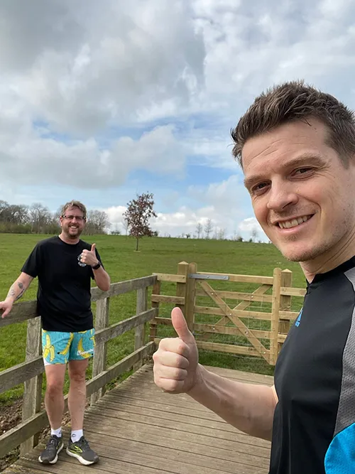 staff with thumbs up out on a run next to field